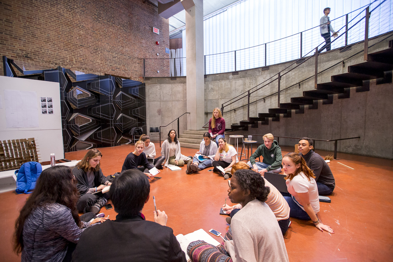 Students sitting on ground, inside pratt building on campus