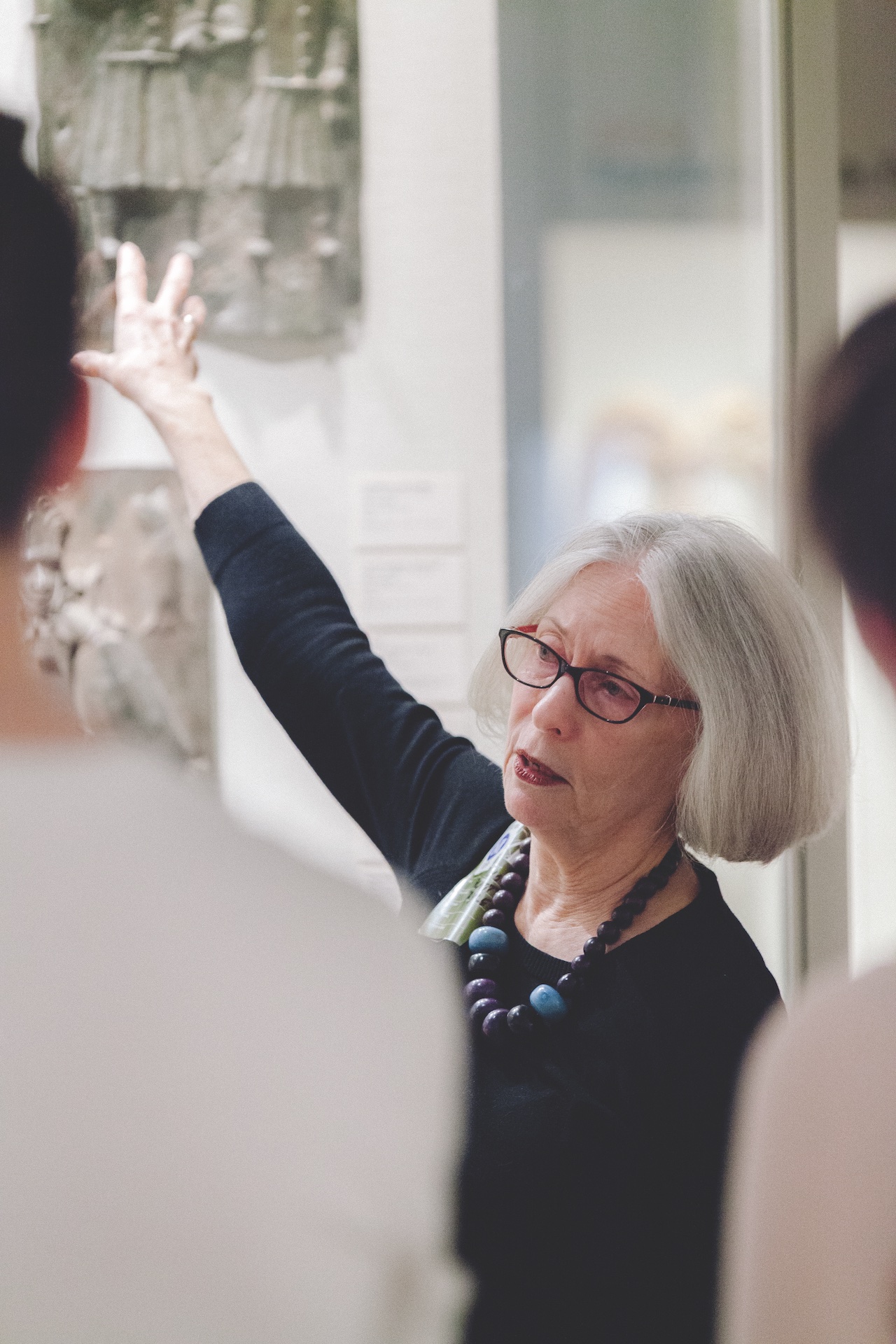 professor leading class, directing their attention with her hands