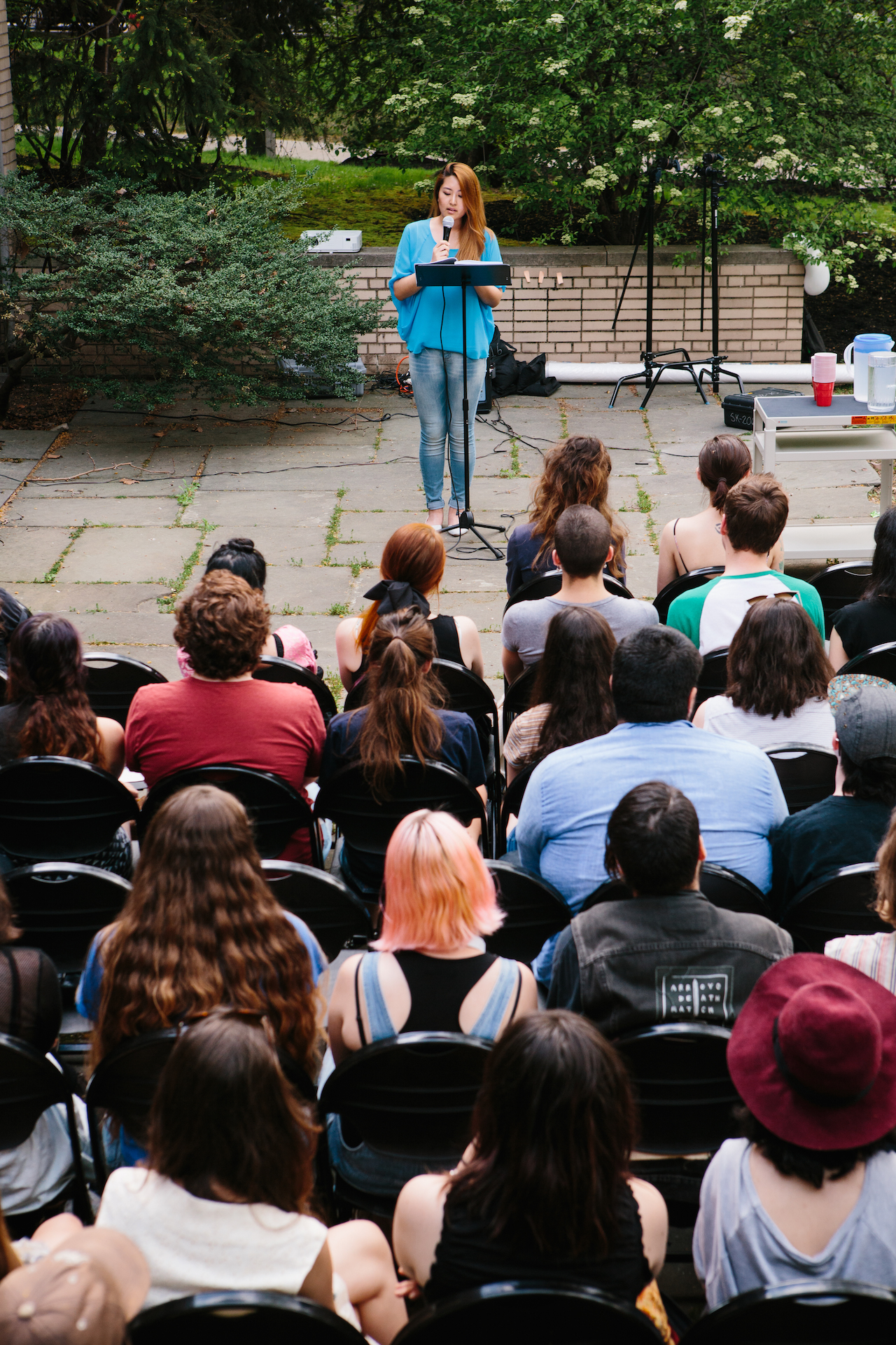 pratt students gathered in front of a speaker on a microphone at a podium