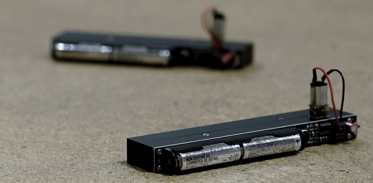 two 'clappers' which are electronic devices, laid down on the floor of a gallery