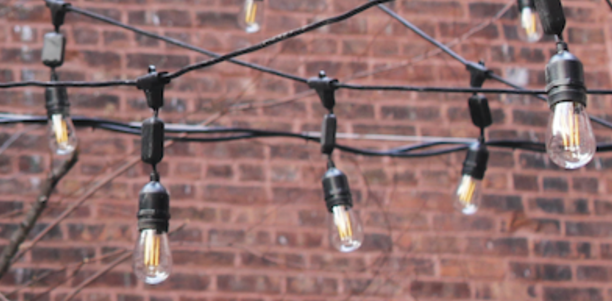 depiction of string lights, in front of brick wall