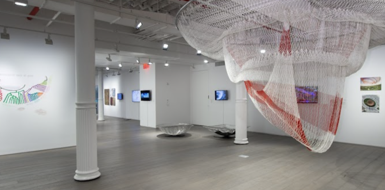 Gallery full of art work hanging from the ceiling and walls