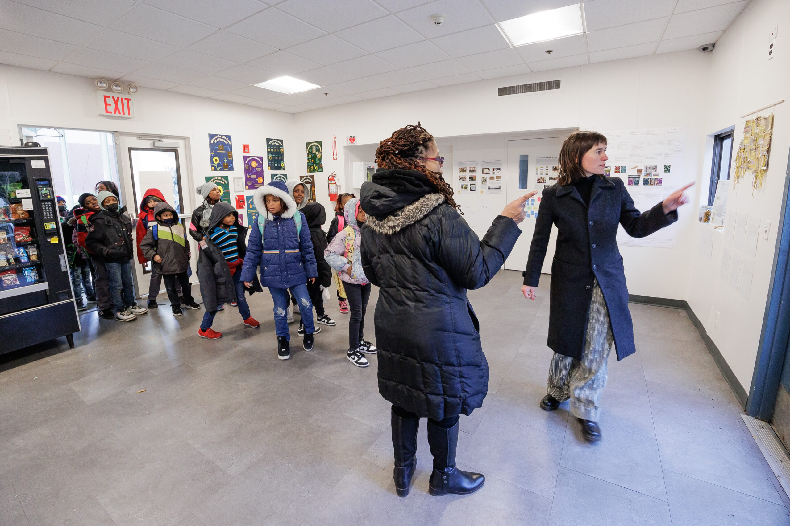 people in gallery room, about 10-20 people, possibly giving a critique