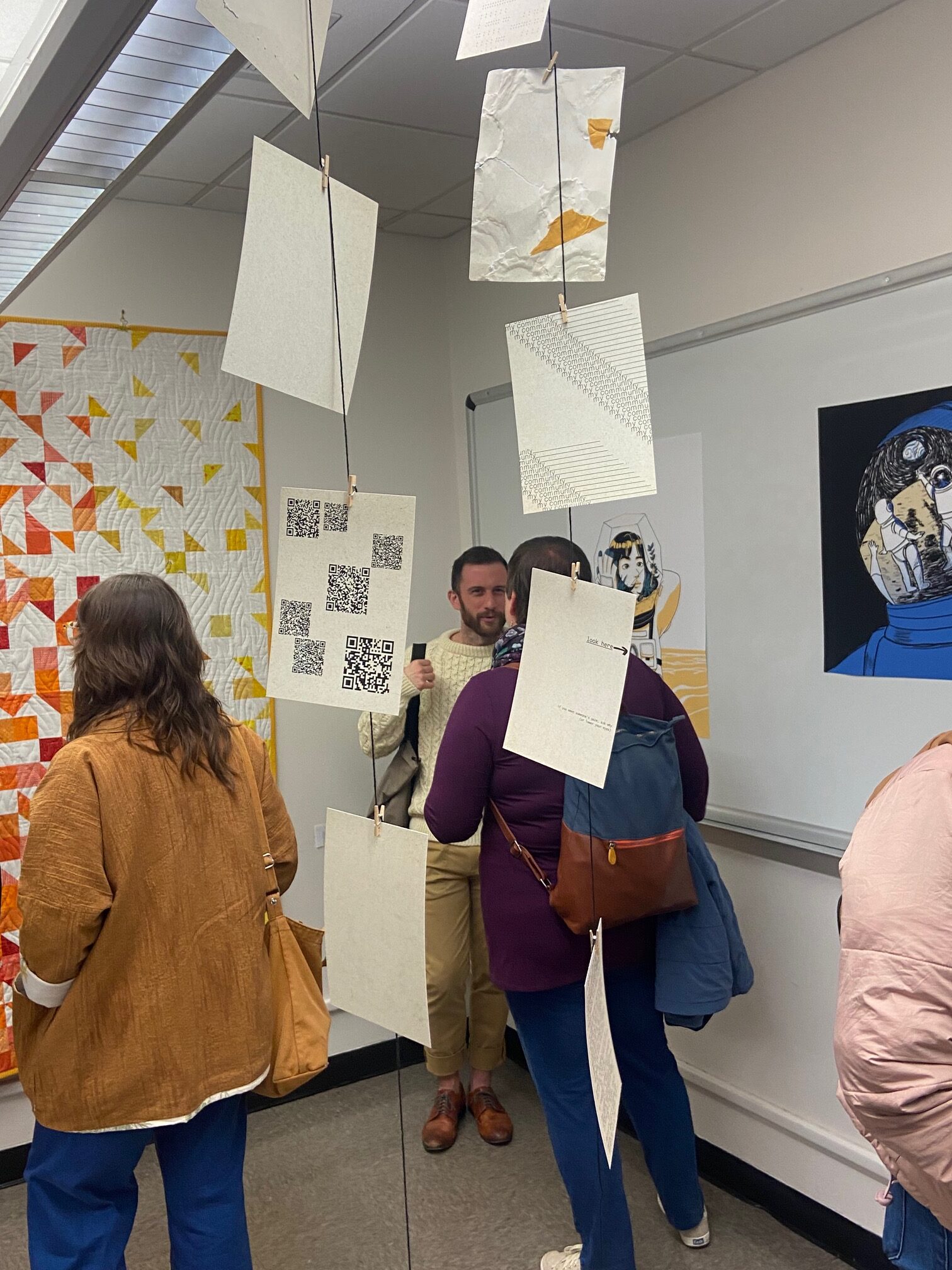 people standing in a gallery with hanging art
