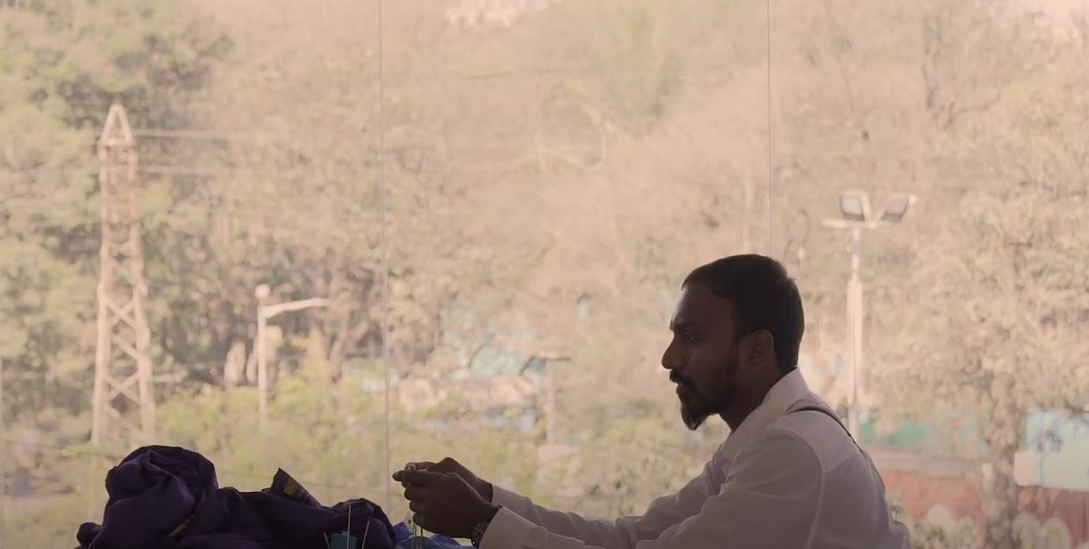 man against a tan wall