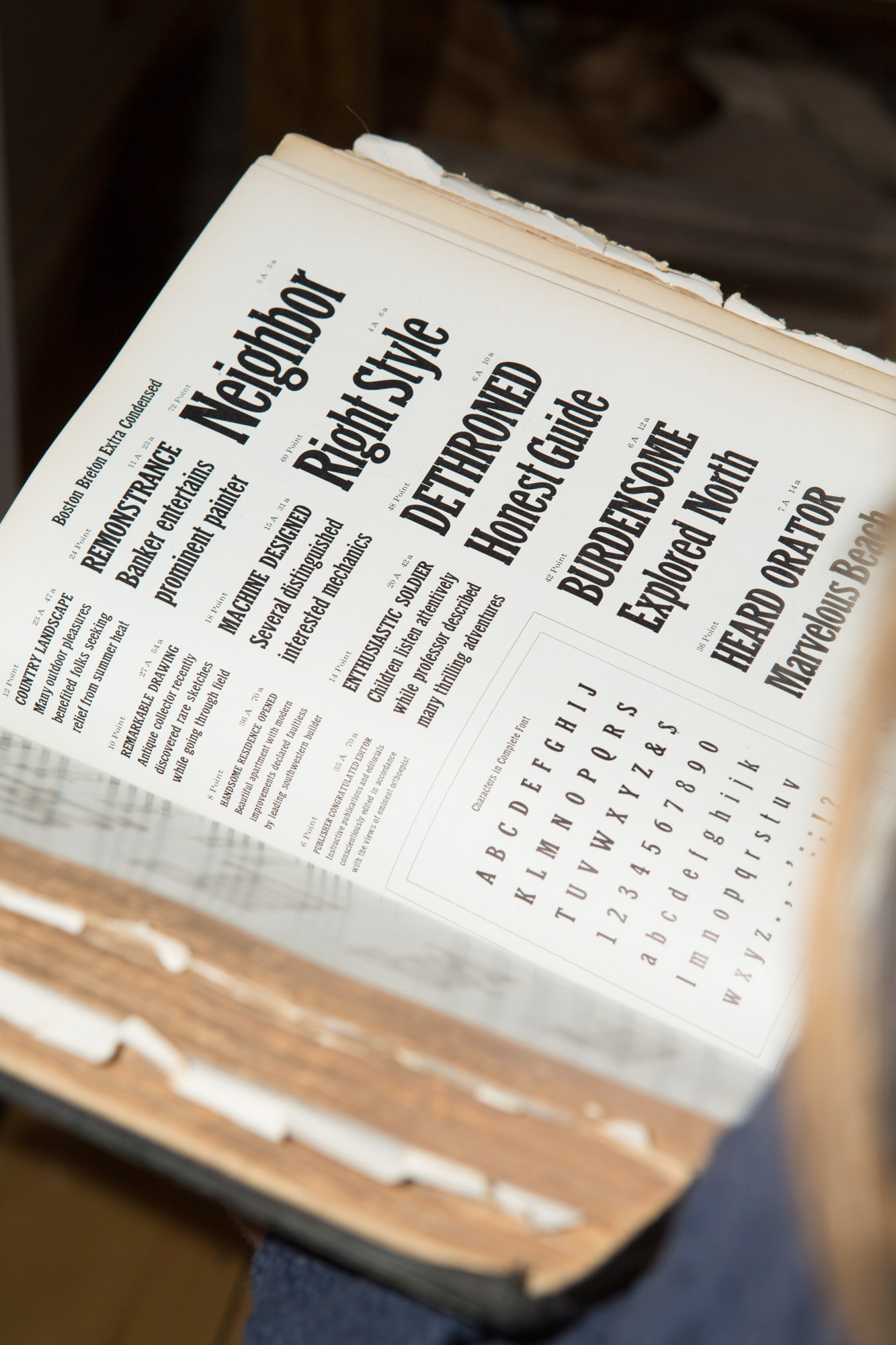 A thick typography specimen book open to a page with thick serif type