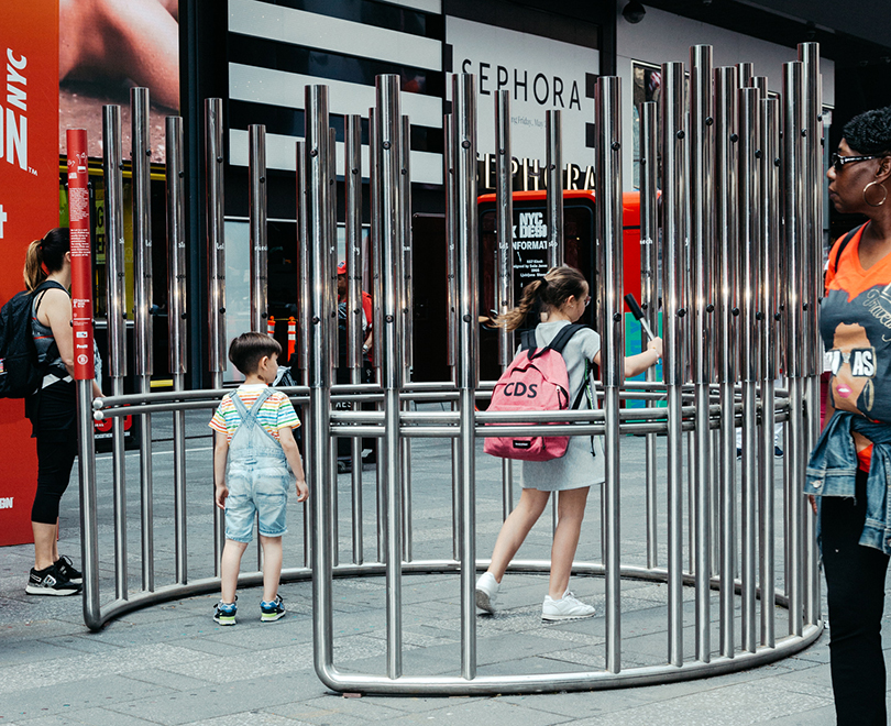 picture of children within the structure playing with the metal bars to make sounds