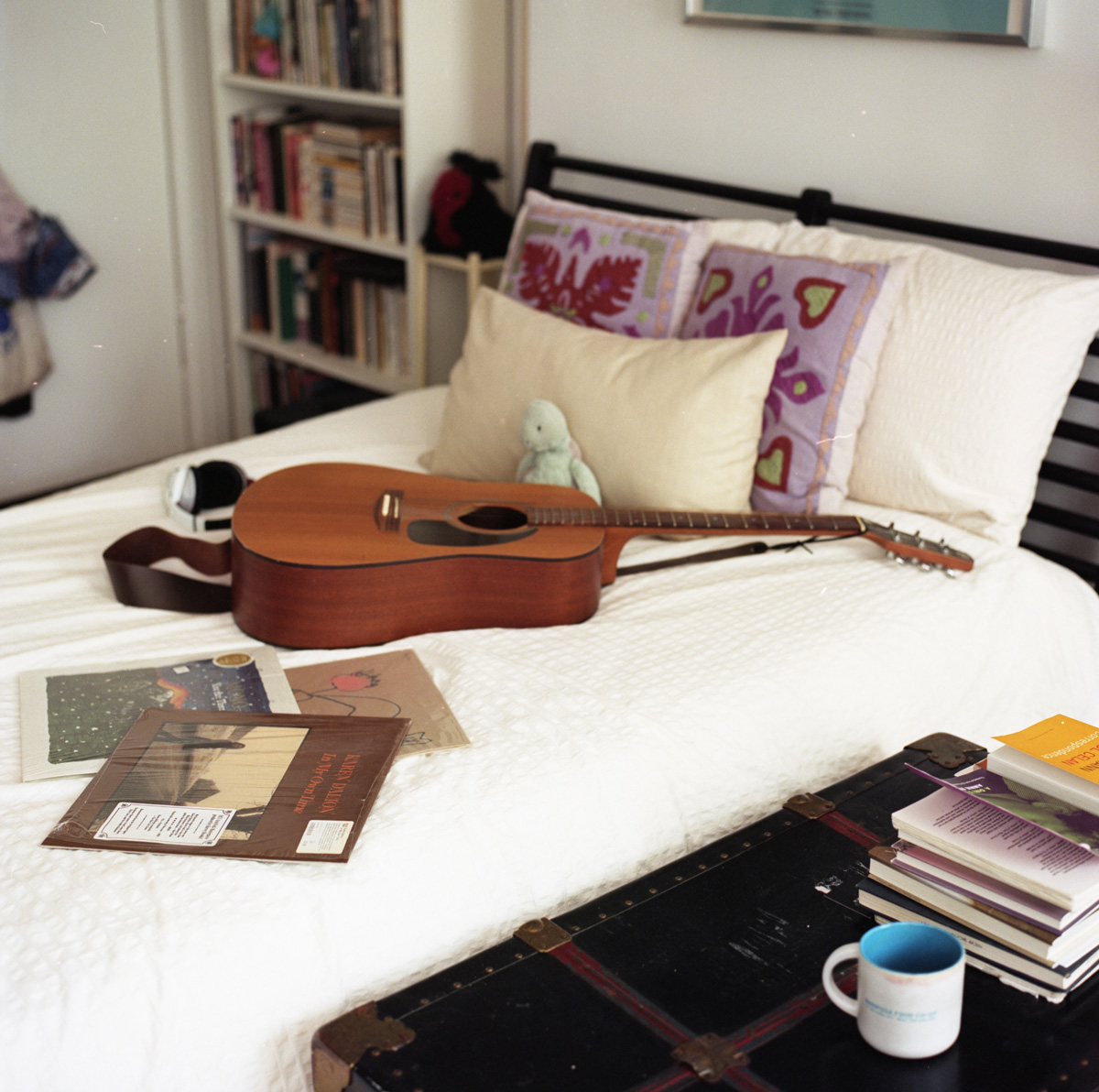 Picture of a guitar on a bed accompanied with books