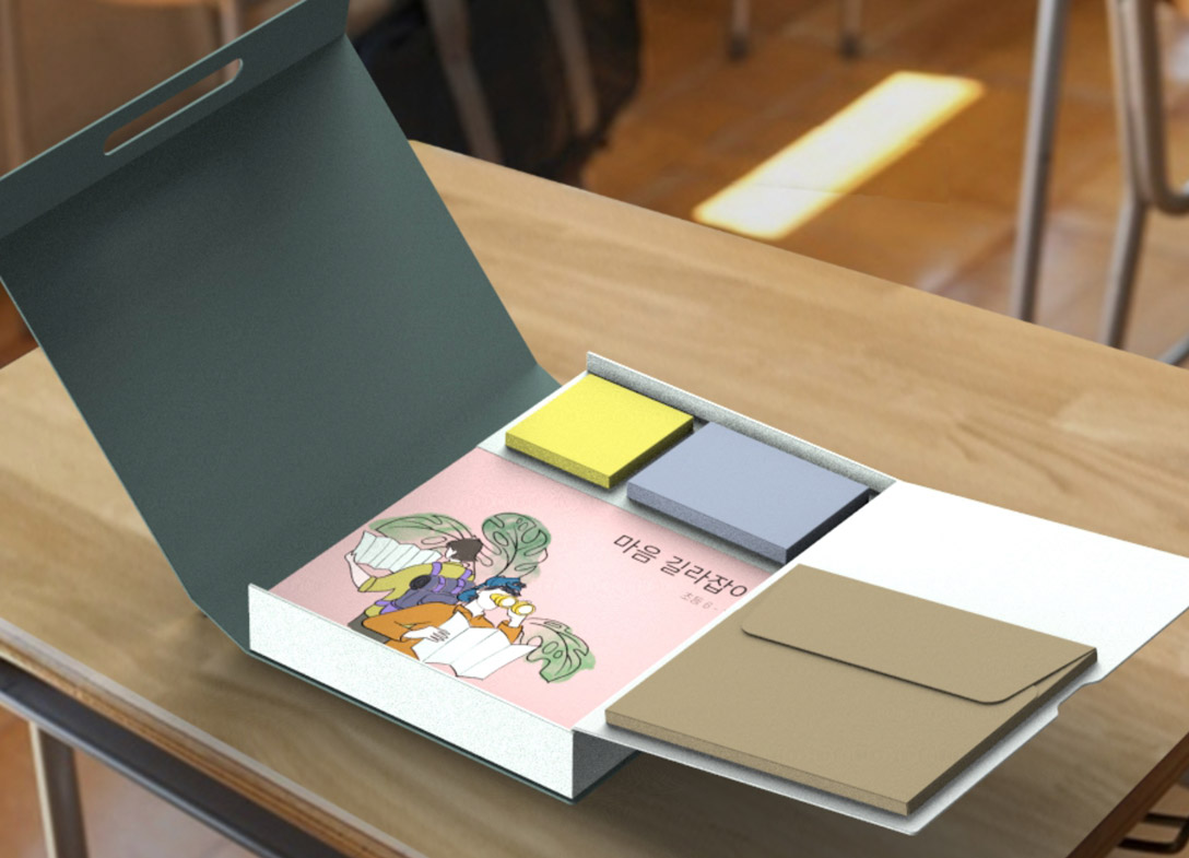 A box with a green lid with a sticky notes of yellow and blue inside, alongside a pink journal with Korean writing on it