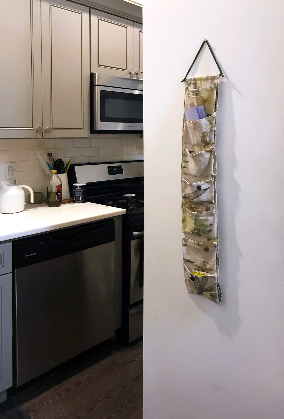 picture of a kitchen with a hanging cloth organizer