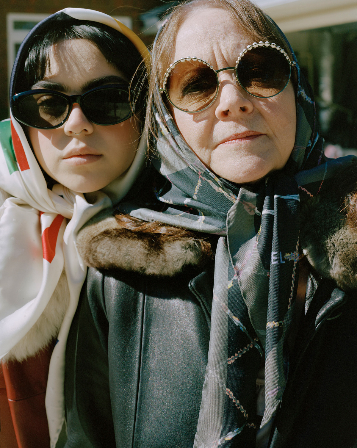 Two individuals in headscarves and sunglasses