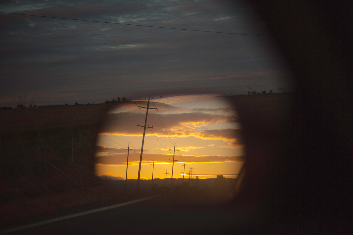 Picture of a reflection of a car side mirror of a sunset