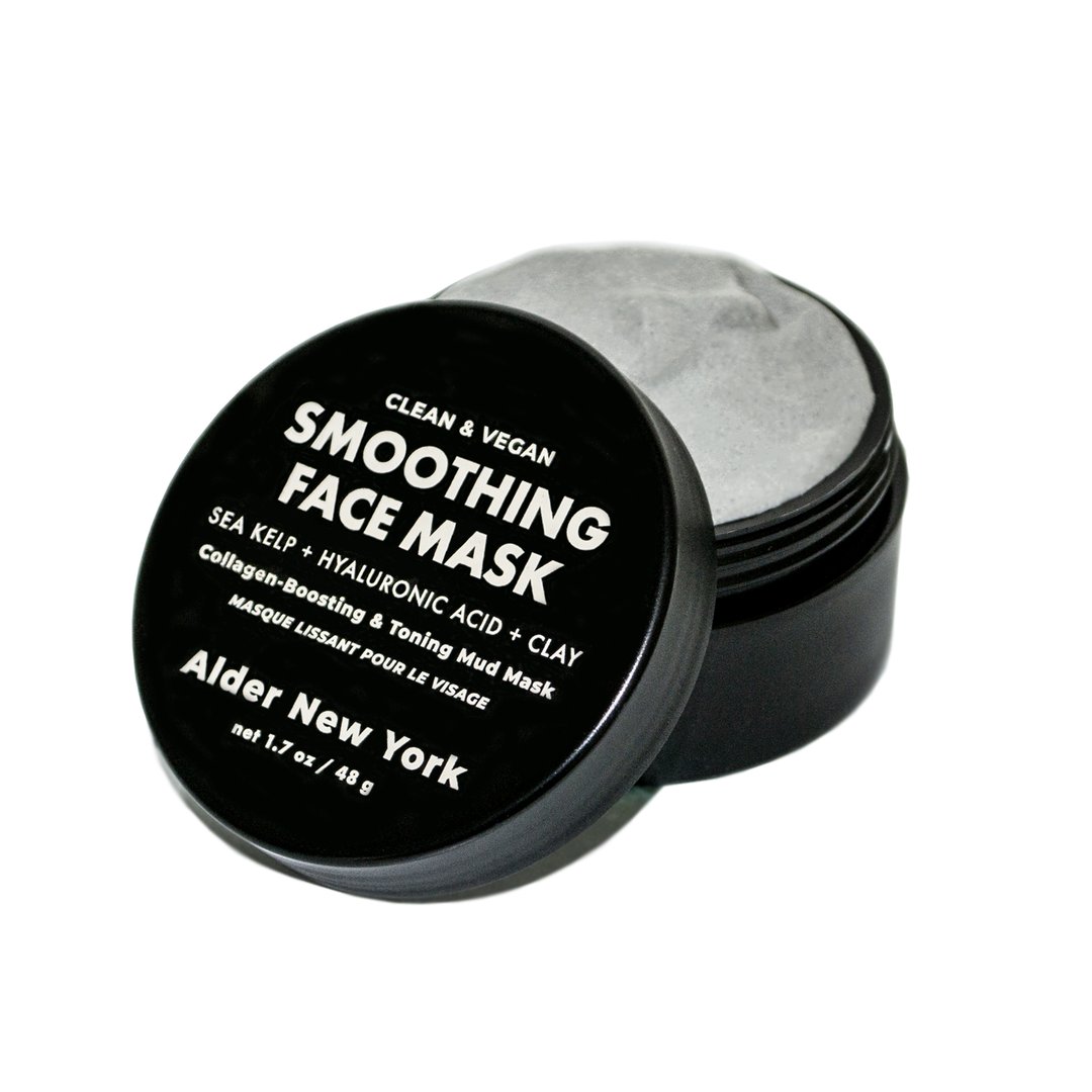 Open black jar of clay face mask
