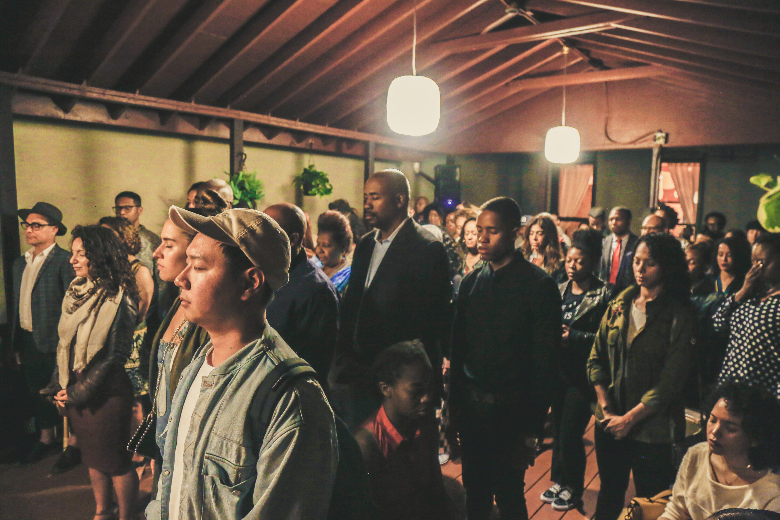 People meditating with eyes closed in a warmly lit space