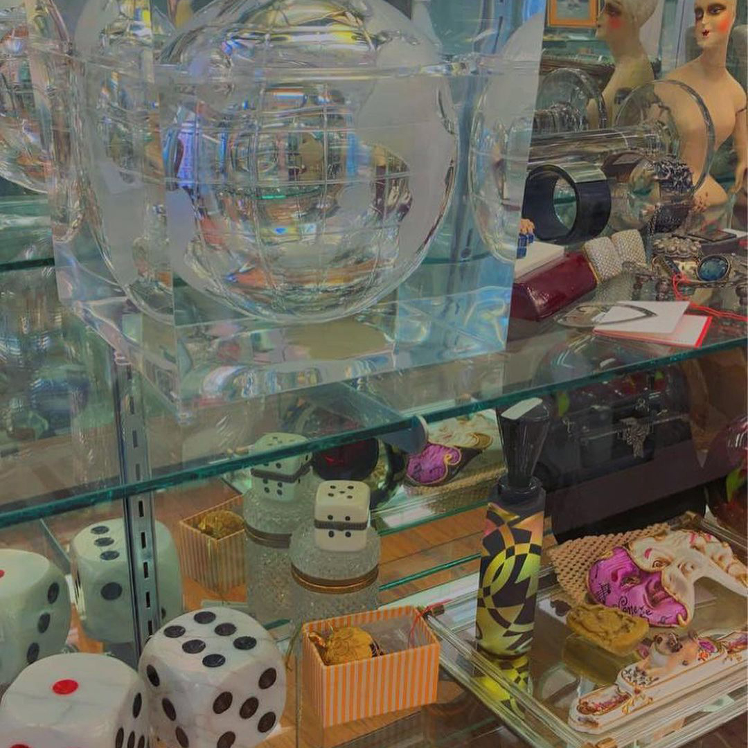 Oversize dice, transparent globe, and other miscellaneous items on glass shelves