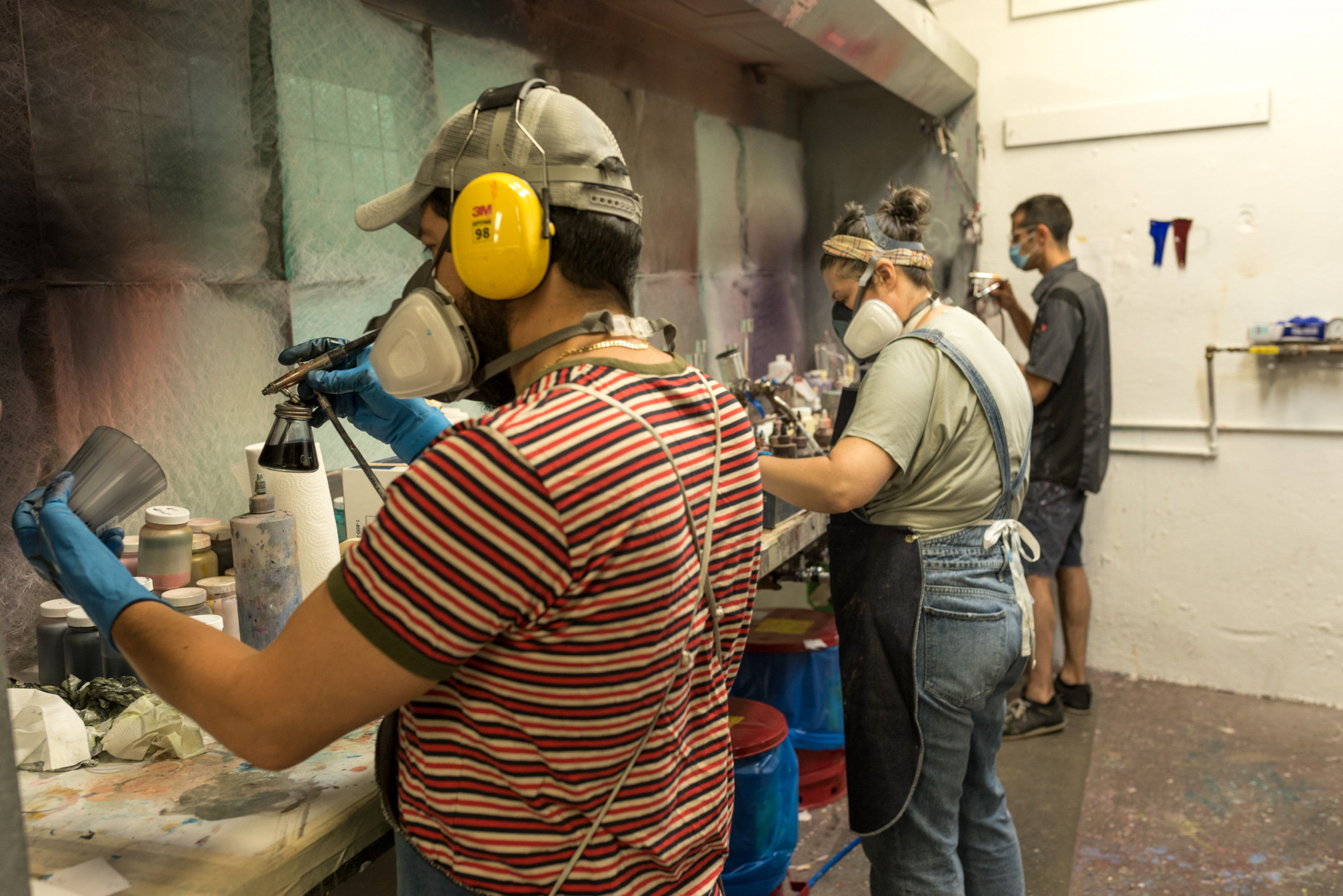Workers wearing PPE airbrush prototypes