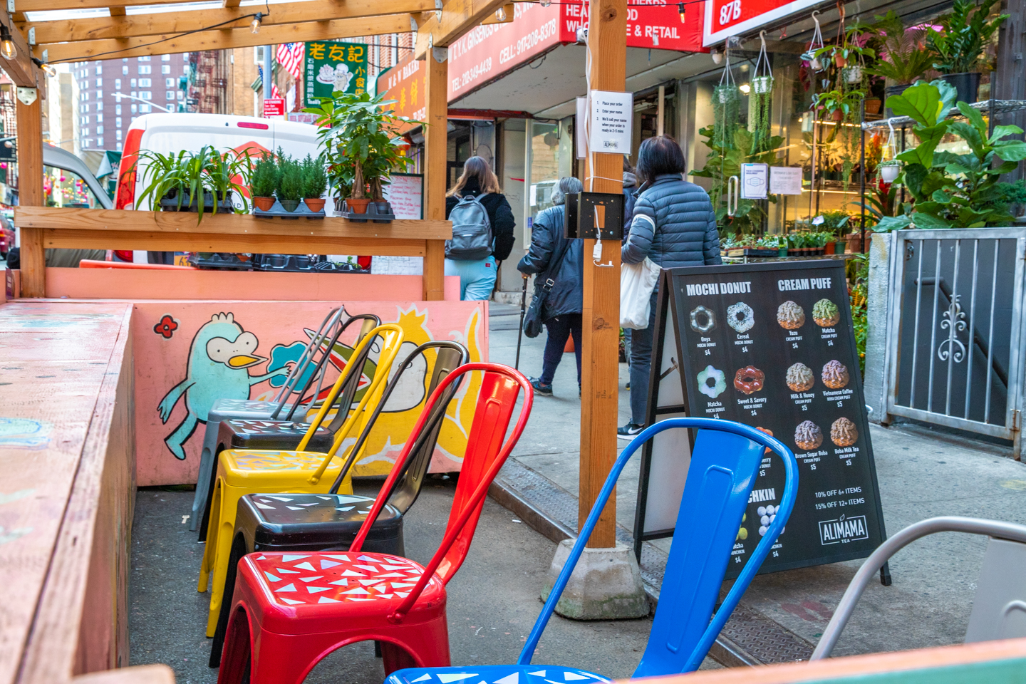 A row of bright metal chairs within a dining structure