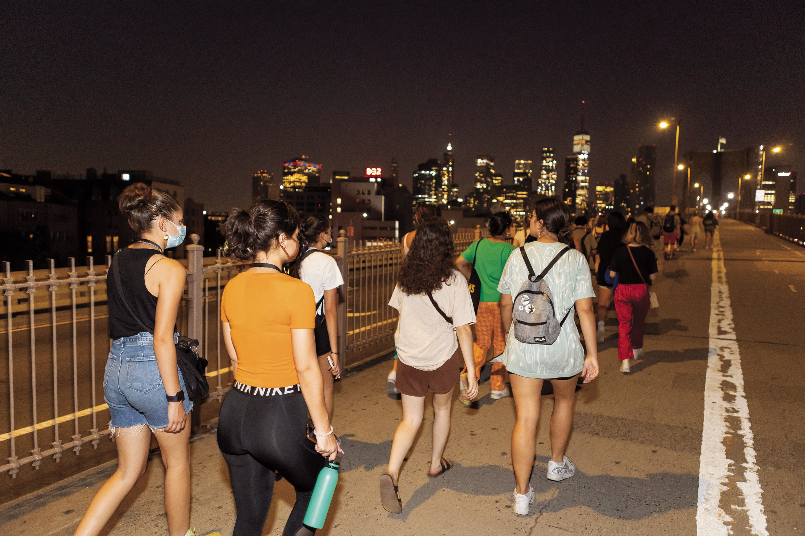 Students walk up the initial ascent of the Brooklyn Bridge from the Brooklyn side before dawn