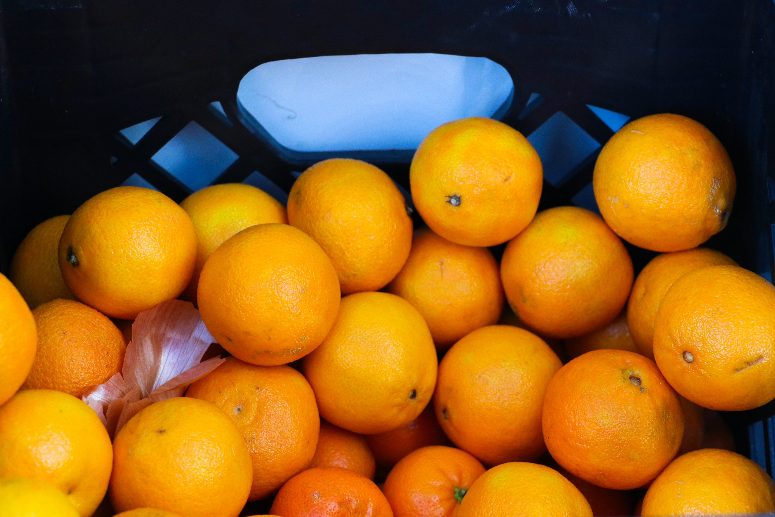 Pile of oranges in a black crate