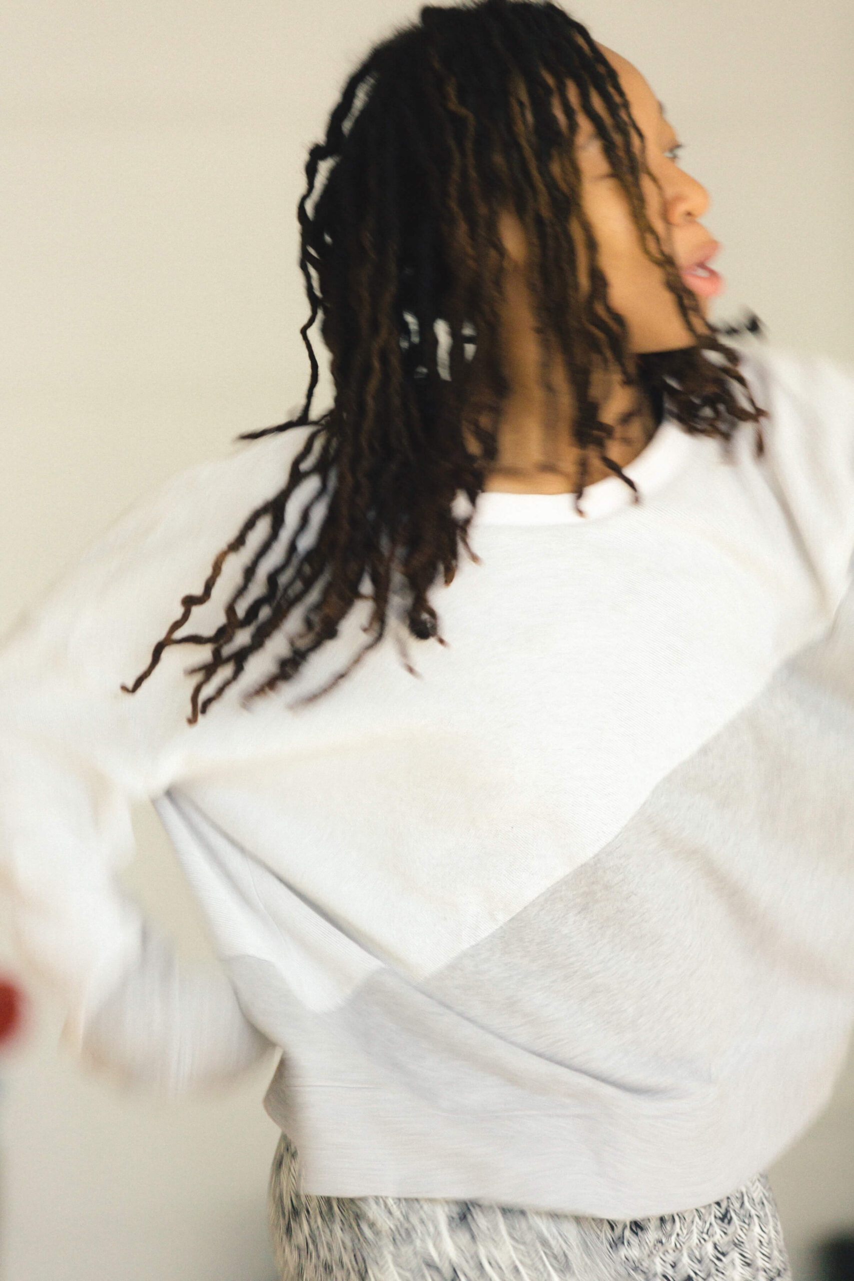 A photo of person wearing a white blouse while looking away from the camera to the side.