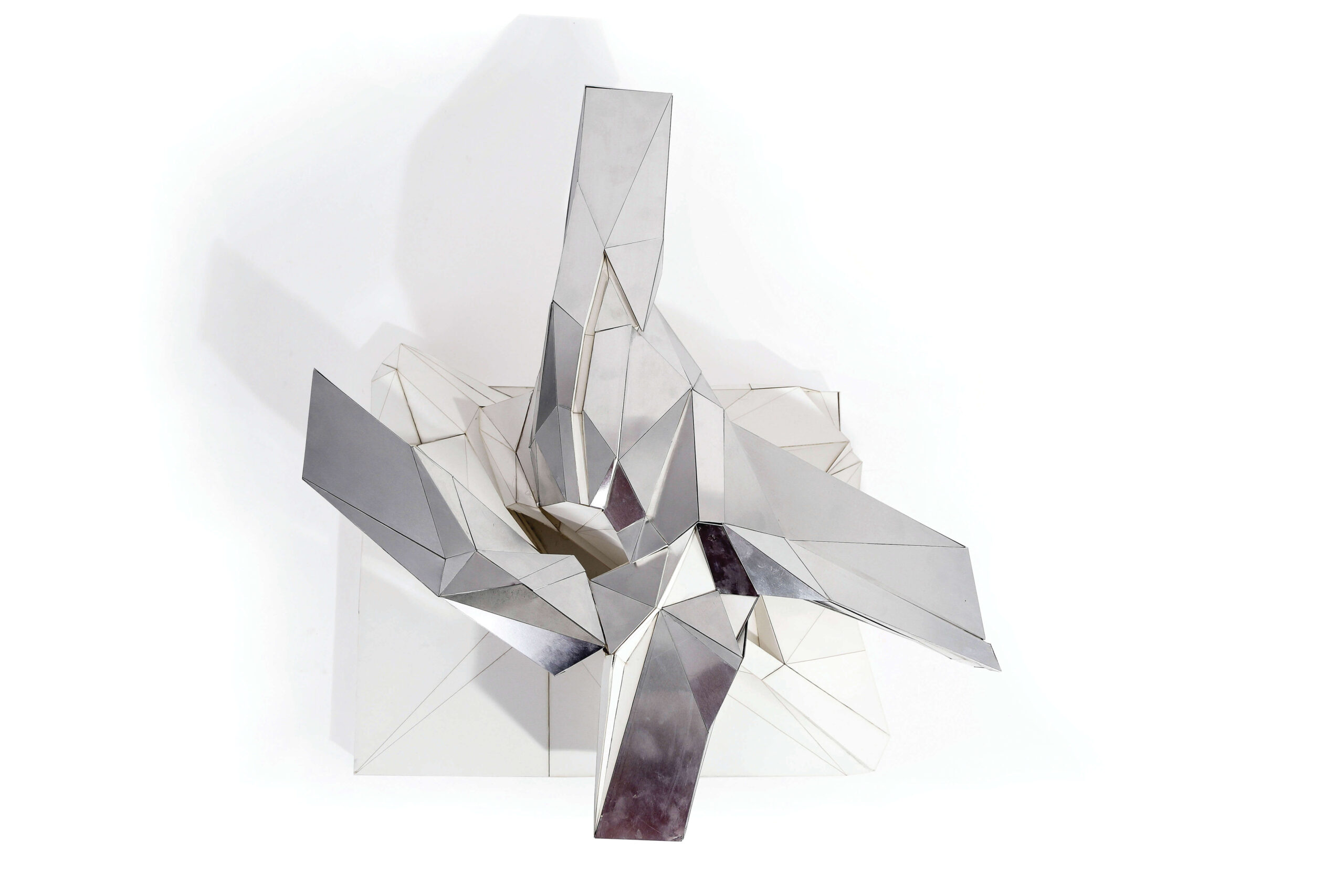 An abstract geometric shape set against a white background. It is composed of wireframes and grey, rectangular panels.