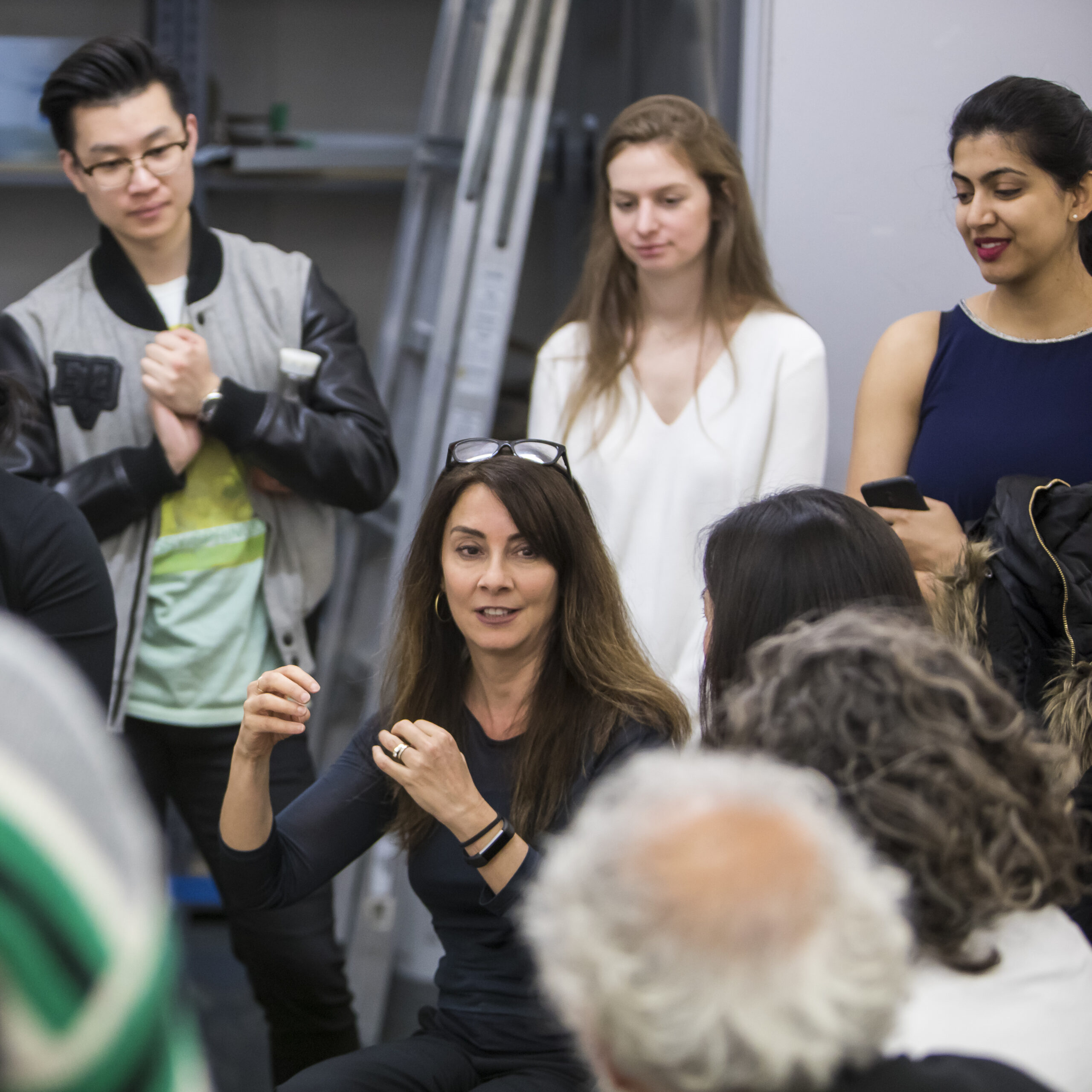 A group of students encircle a faculty member who is speaking intensely.