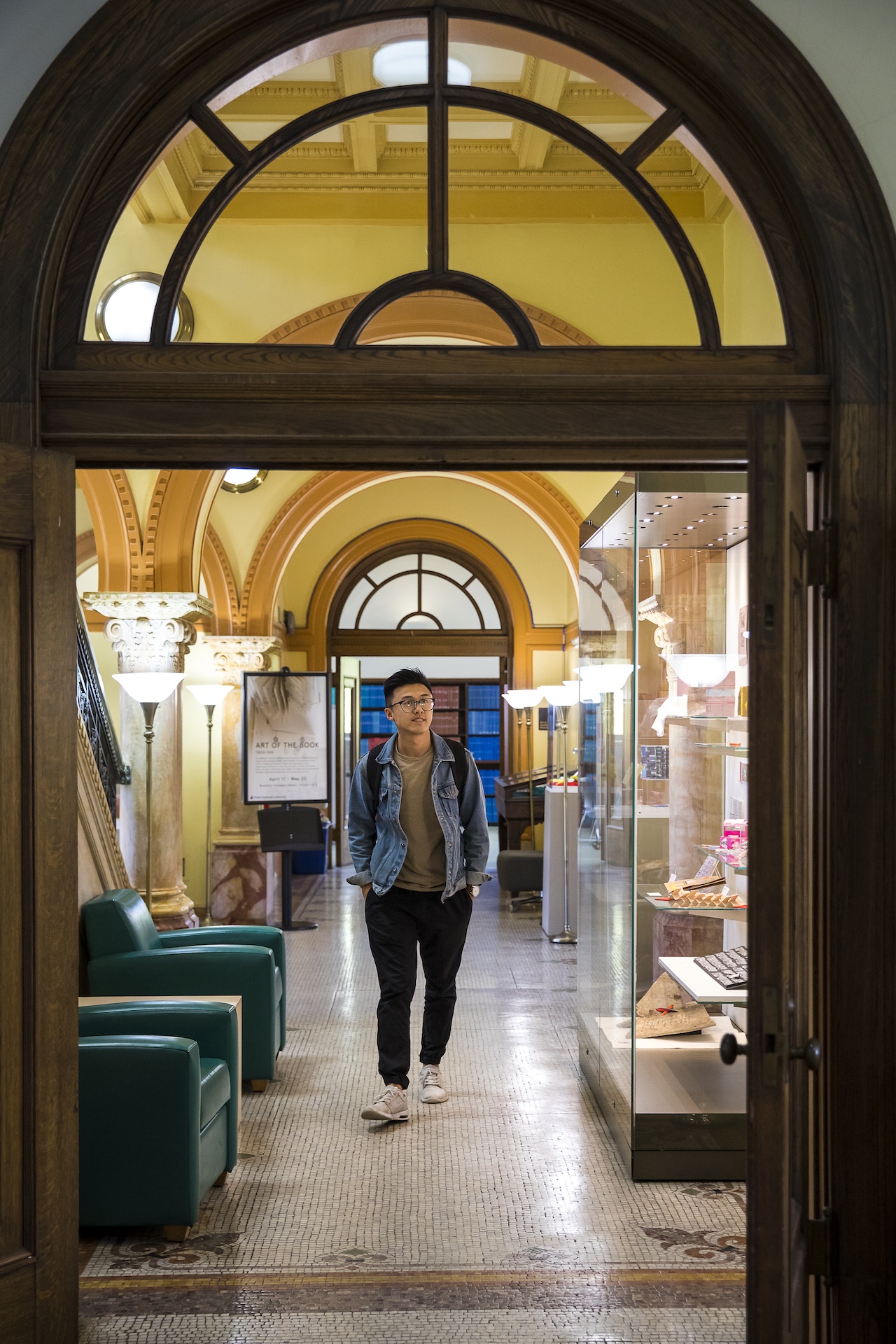 student on campus, walking through pratt library