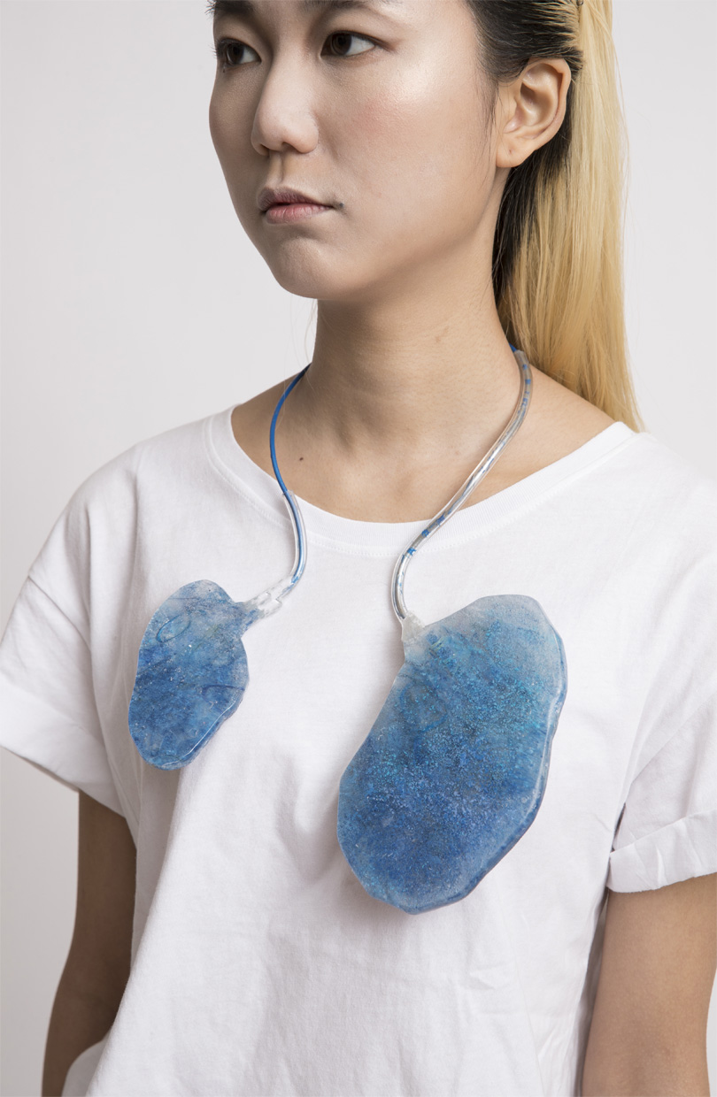 Picture of a female individual wearing a blue-colored neckpiece resembling lungs