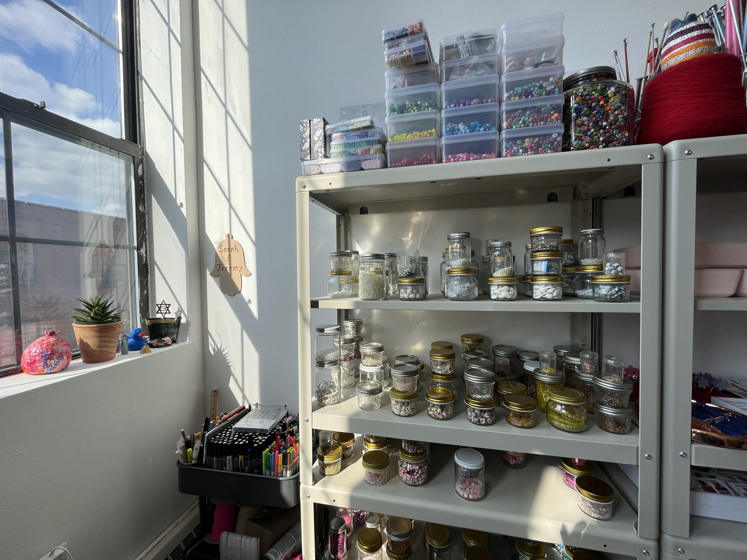Shelves of glass jars with beads and jewelry-making materials