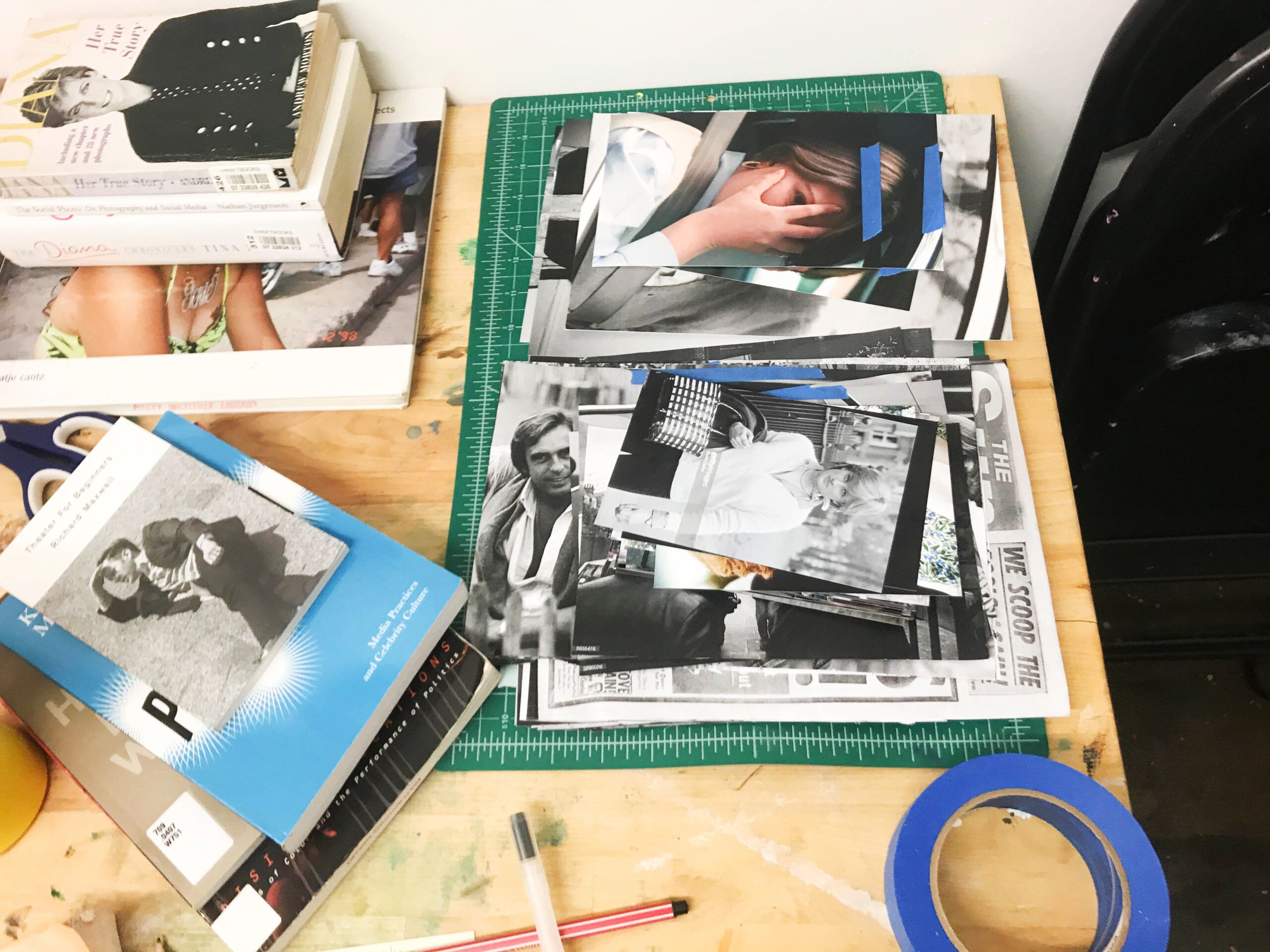 a photography student's work table with images, books, and creative tools