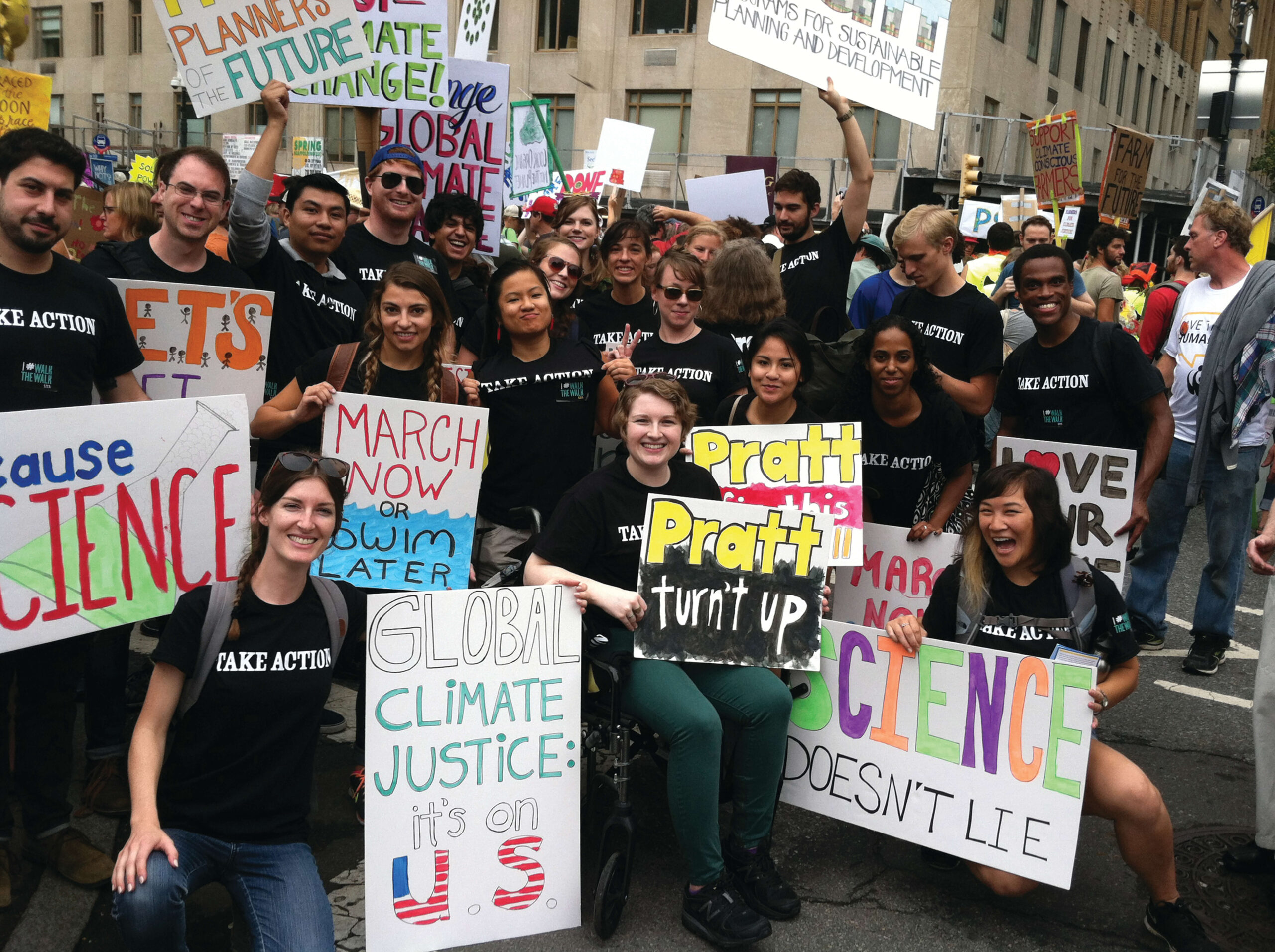 A group of Pratt student stand for a group photo during a rally in support of further action against climate change.