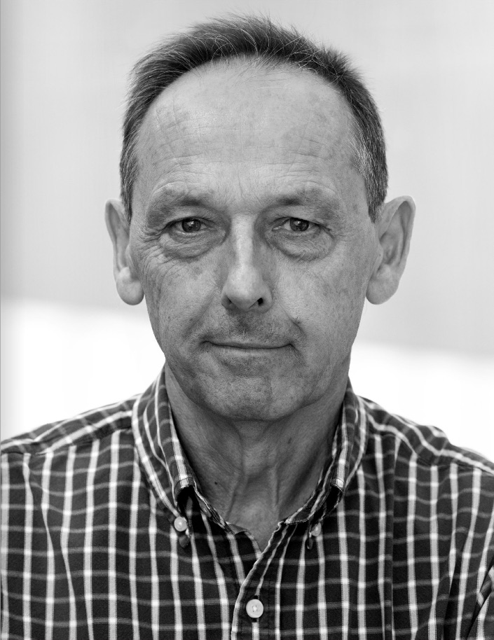 headshot of david burney, wearing a plaid button-up shirt, black and white photo