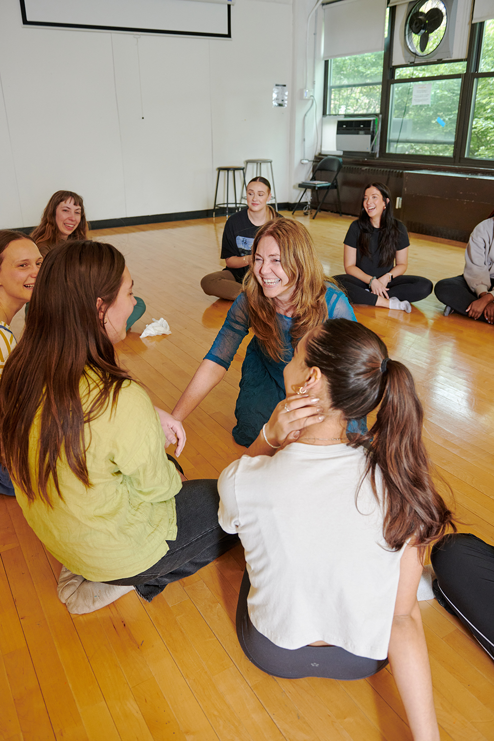 Students in Dance Therapy class sit in a circle on the dance studio floor.