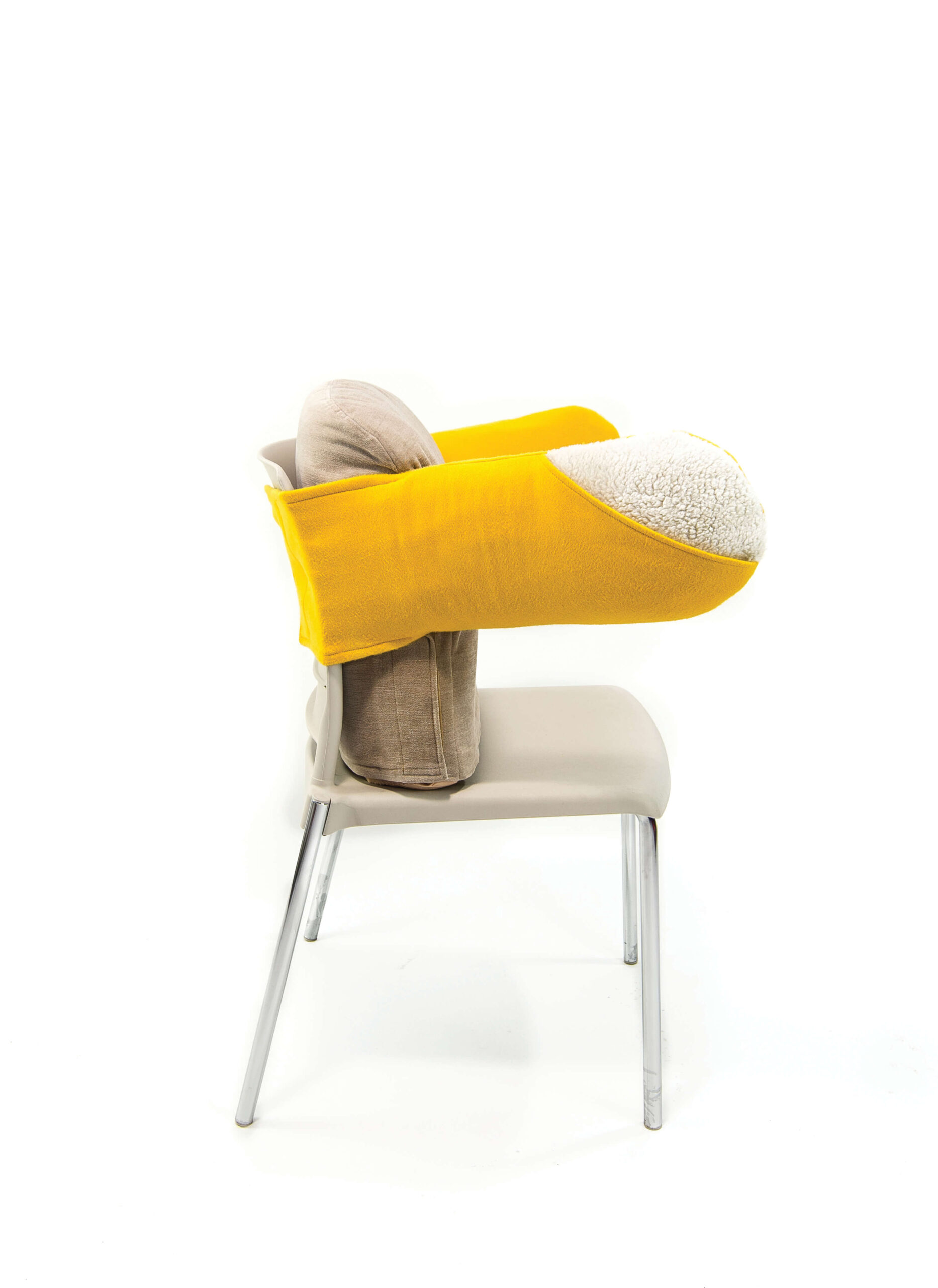 Side view of a chair with oversized armrests in yellow. The rest of the chair is grey. The arm rests are made of a plush material, while the rest of the chair is made of plastic. The chair is set against a white backdrop.