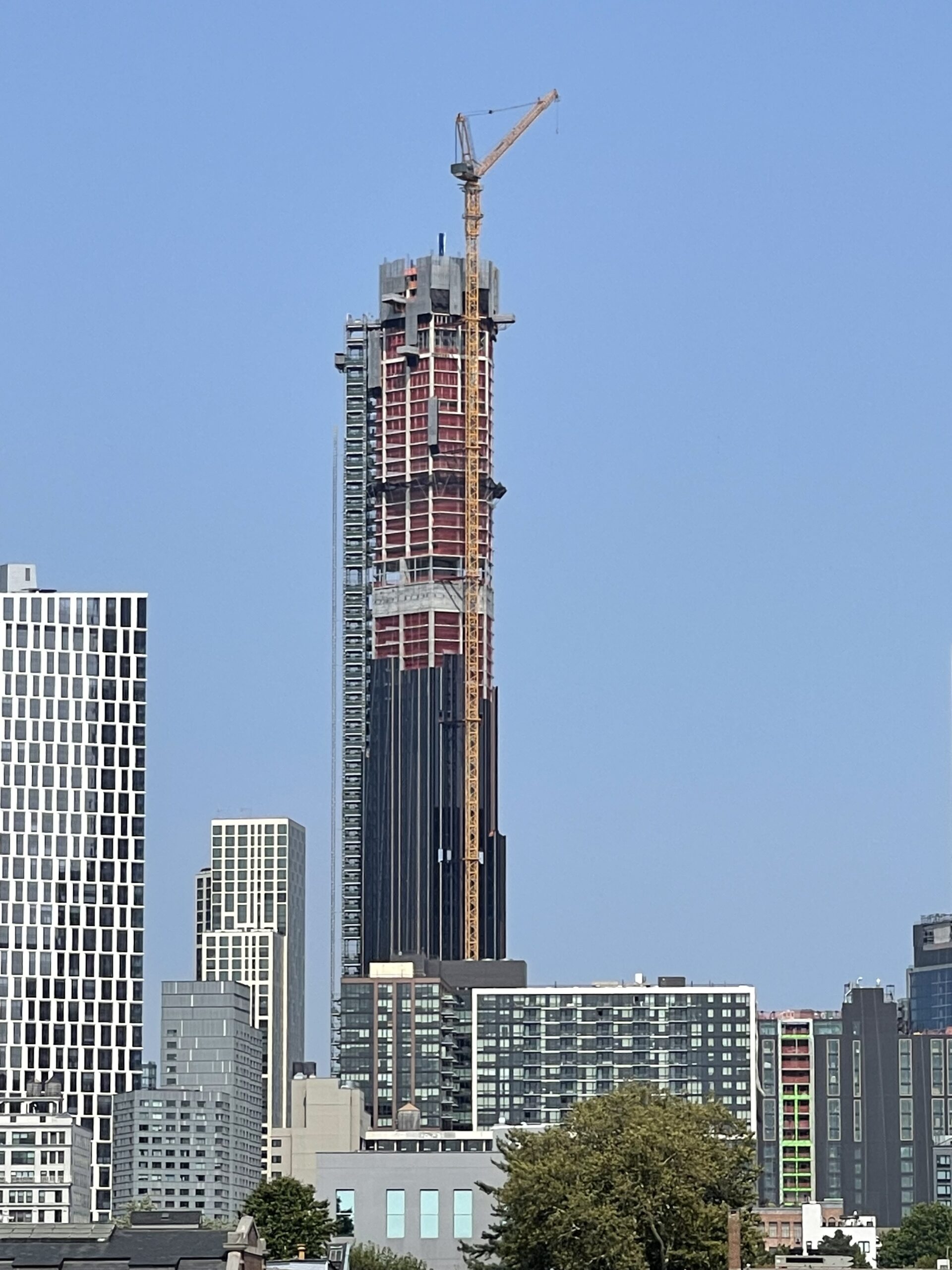 A skyscraper under construction viewed from afar.