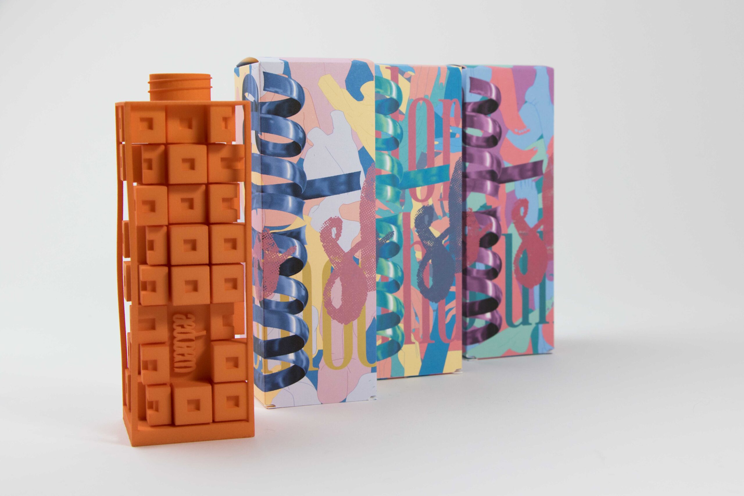 Package design including a box with graphics of cursive writing resembling silk bows, with a sculpture, voxel like design