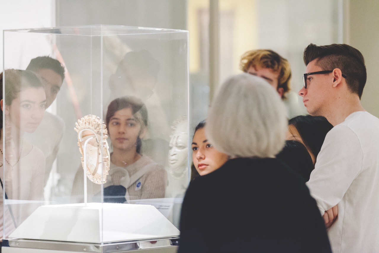 professor speaking with class, reviewing artwork onsite