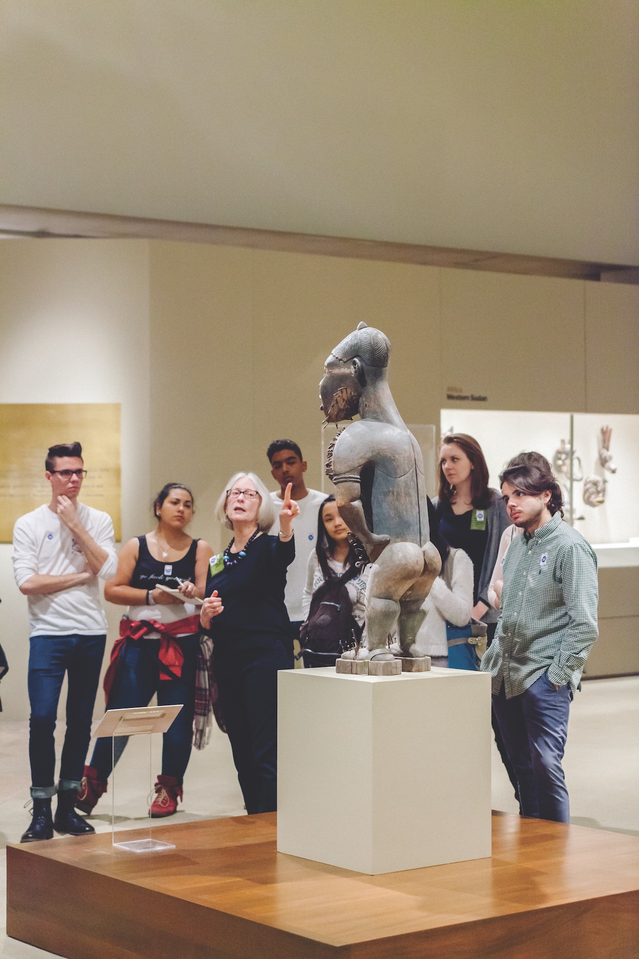 professor speaking with class, reviewing african artwork onsite