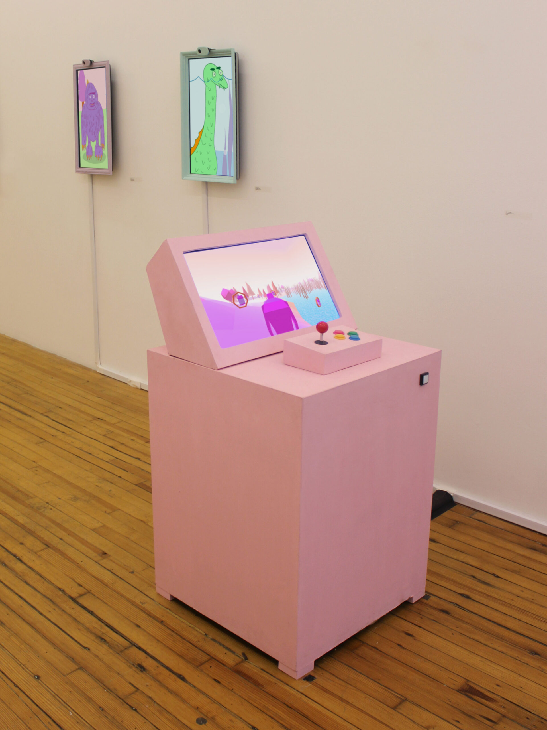 Photo of a gallery focusing on a pink custom made game console with a screen and controls.