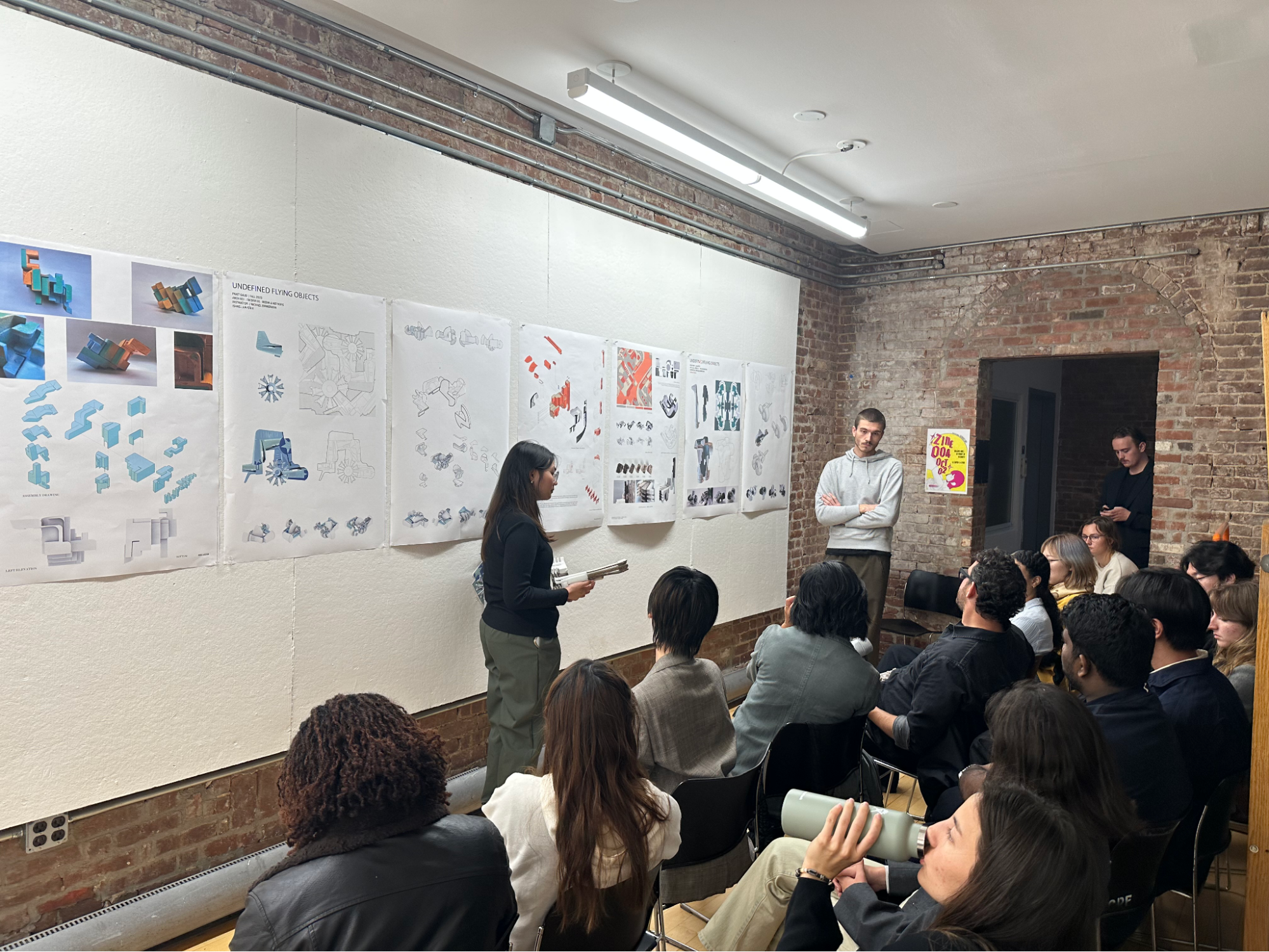person standing at whiteboard, students onlooking