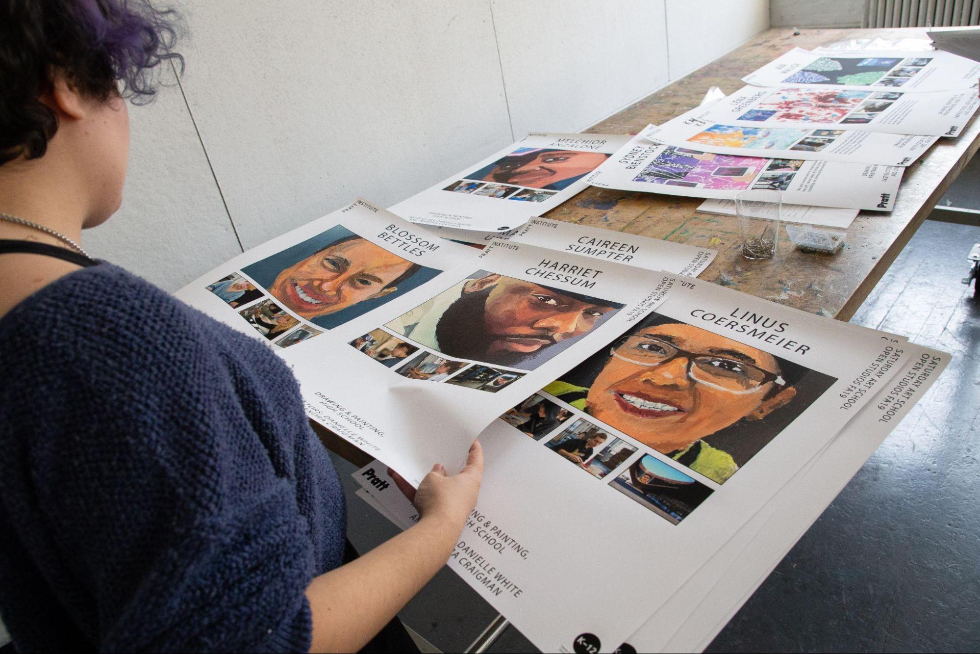 Student-teacher in Saturday Art School selecting posters for Open Studio exhibition.