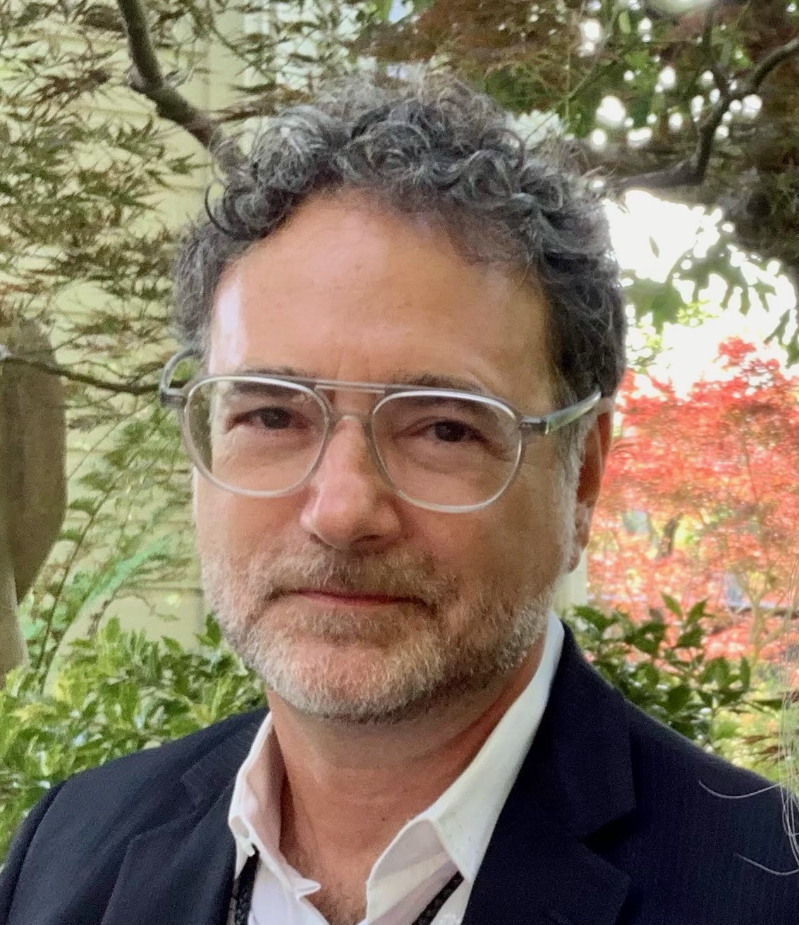 Headshot of John Beller, standing in tree-lined area