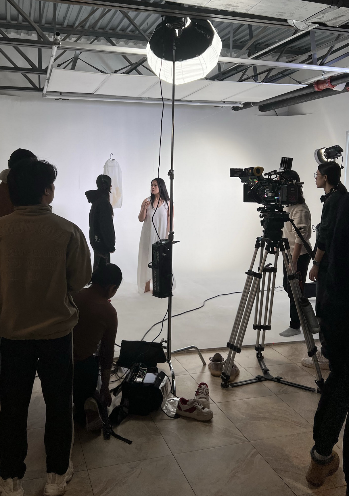 flim set, models and camera in background, directors in foreground