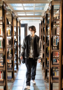 Student passing through the book stacks in the historic Pratt Library on the Brooklyn campus