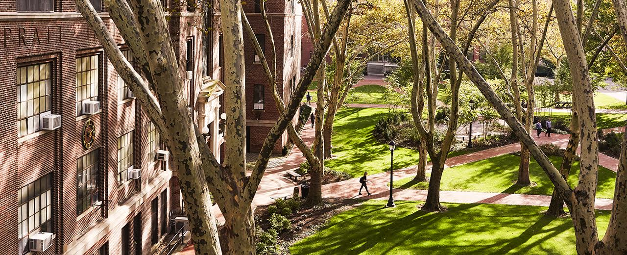 Photo of a red brick building alongside a park.