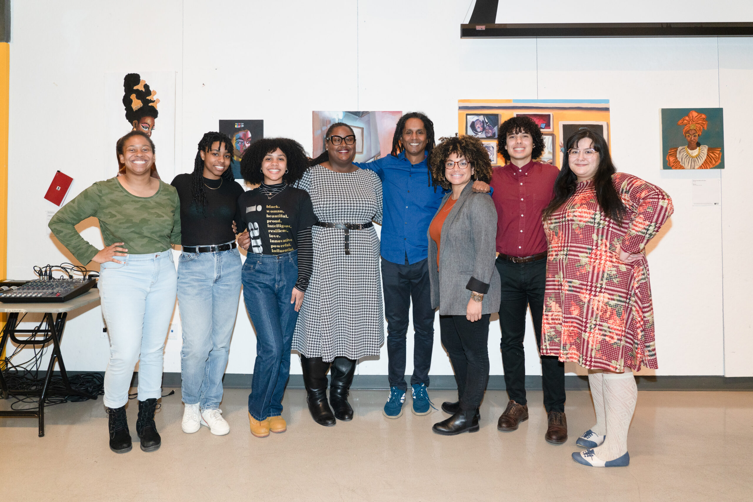 A group of students pose for a group picture with a white wall with a few pictures behind them during the 2020 MLK Jr Breaking Bread Event.