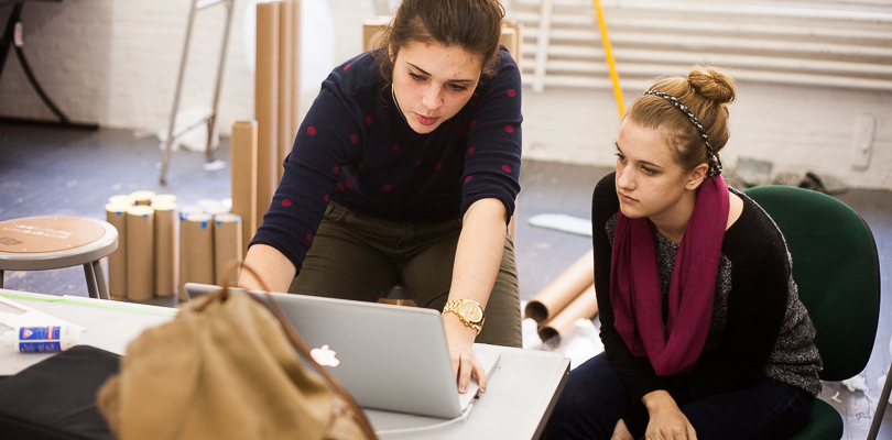 Two student look attentively at a laptop screen