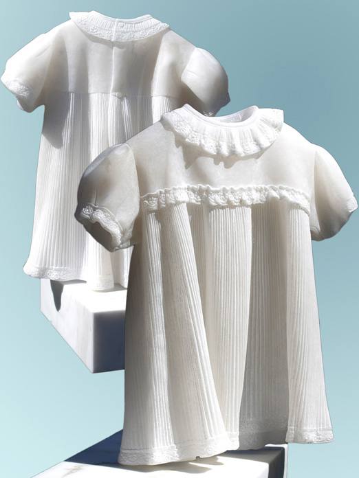 two white baby dresses in a light blue background