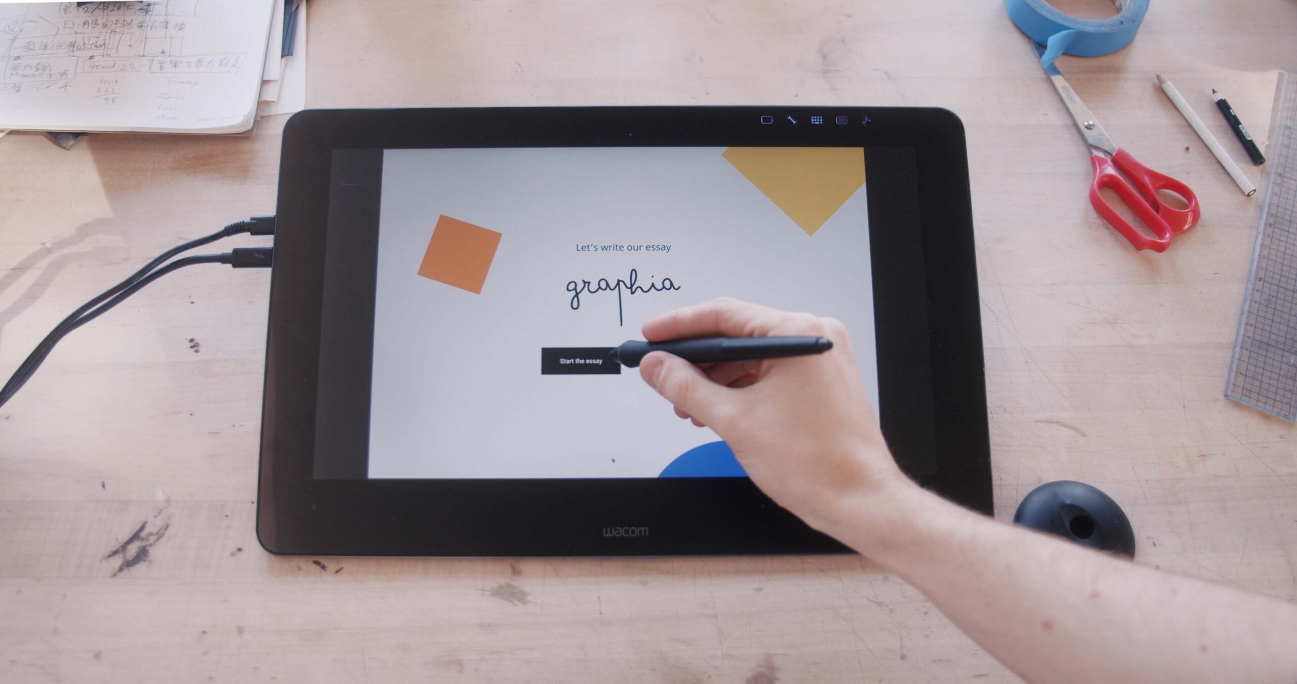 image of a tablet with hand holding special pen and Graphia tool on the screen of the tablet.