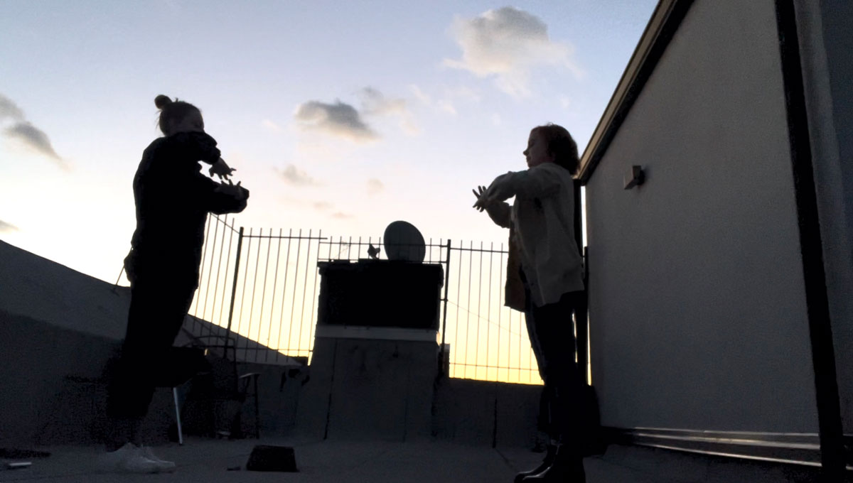 Two women dancing on a rooftop